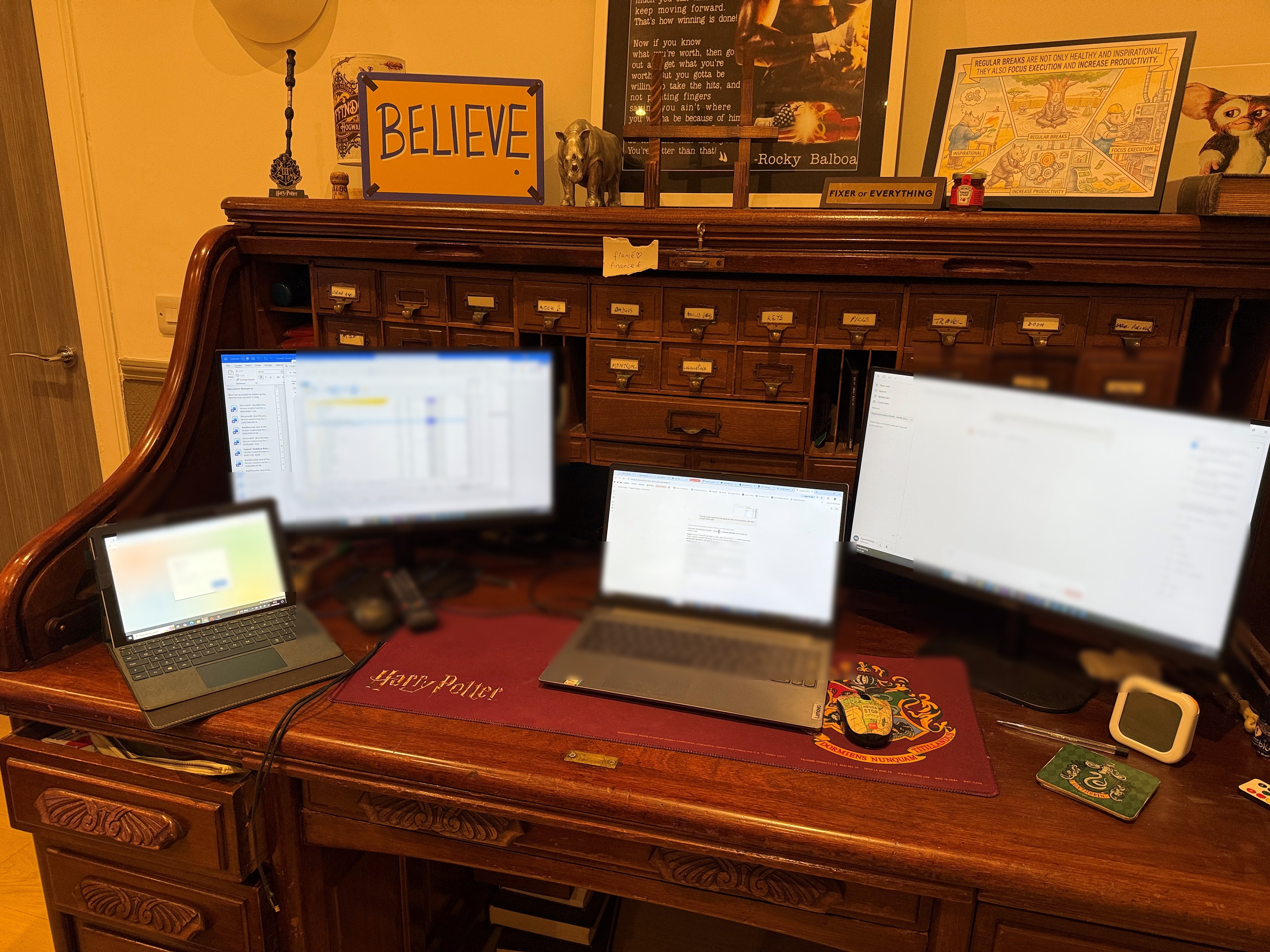 Jamie's home office, a vintage roll-top desk with a BELIEVE sign and several screens